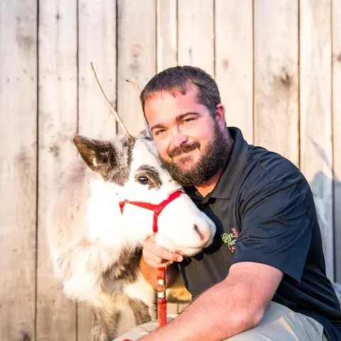 a man holding a dog posing for the camera