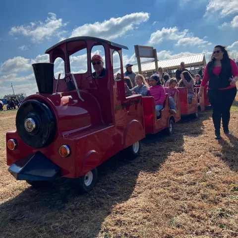 a group of people standing next to a tractor