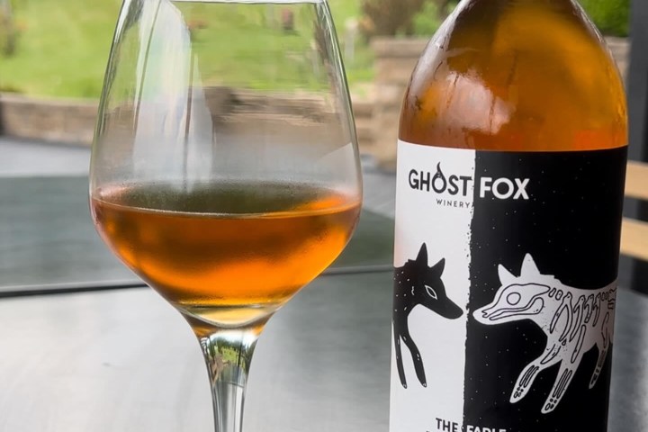 a close up of a bottle and a glass of wine
