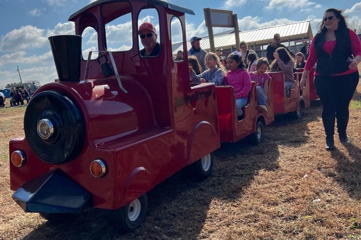a group of people standing next to a tractor